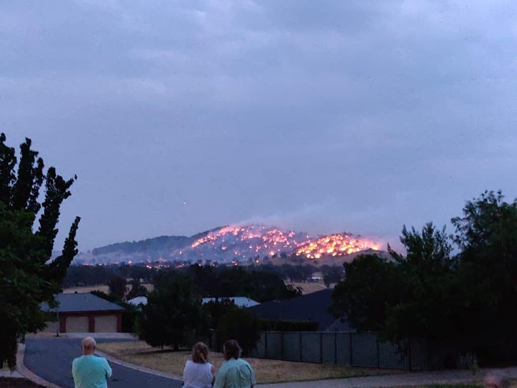 Fire burning on hills adjacent to suburban communities