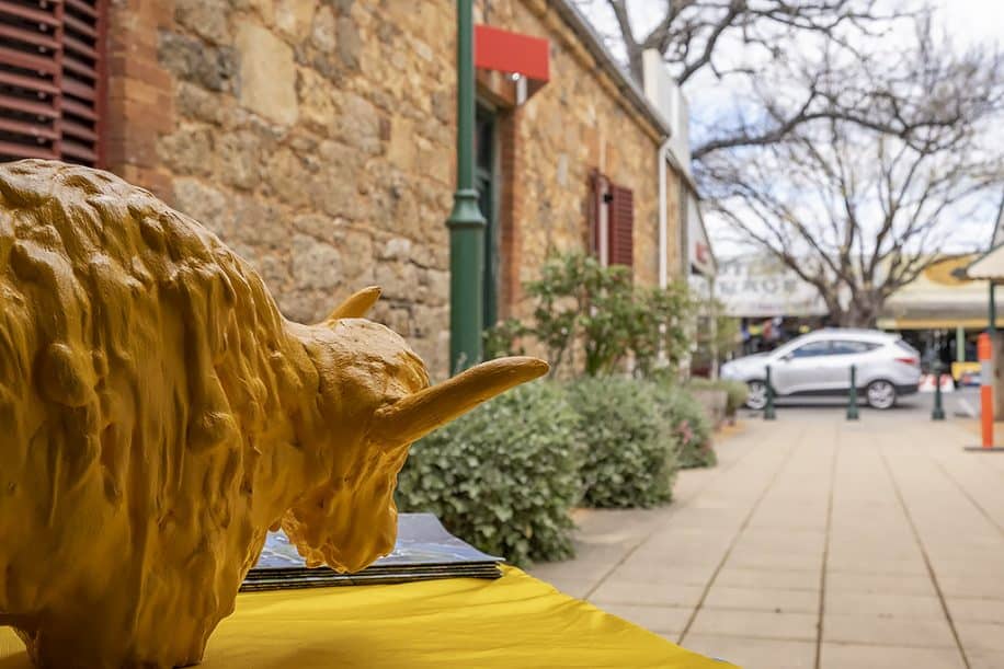 A plaster statue of a golden yak watches the laneway outside the Yackandandah post office